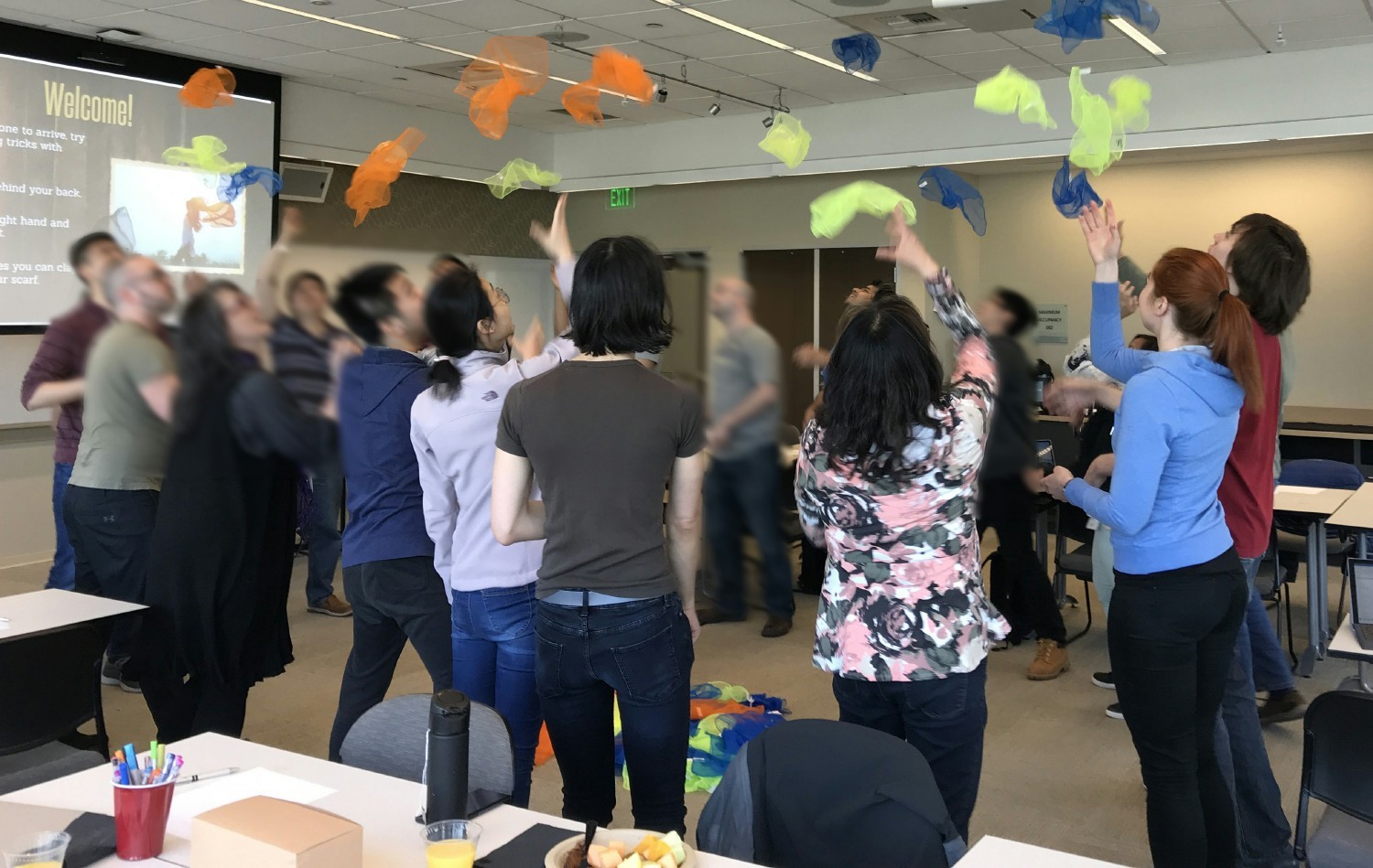 Photo of workshop participants throwing colorful handkerchiefs into the air